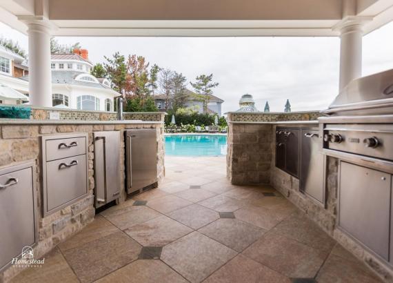 Elegant outdoor kitchen with stainless steel appliances and recycled sea glass countertops