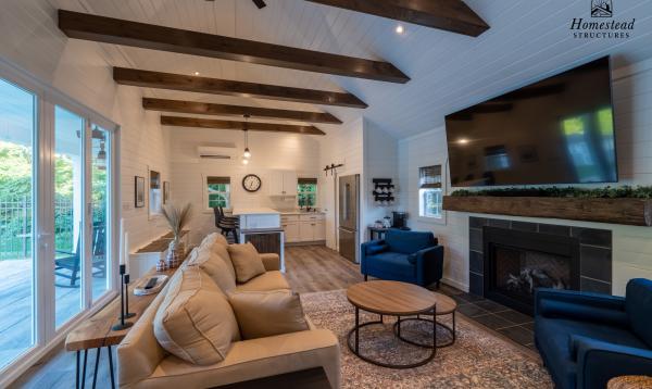 interior of custom built pool house with bifold doors, fireplace, exposed beams and tongue and groove ceiling