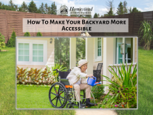 An older adult using a wheelchair to water the garden in their backyard.