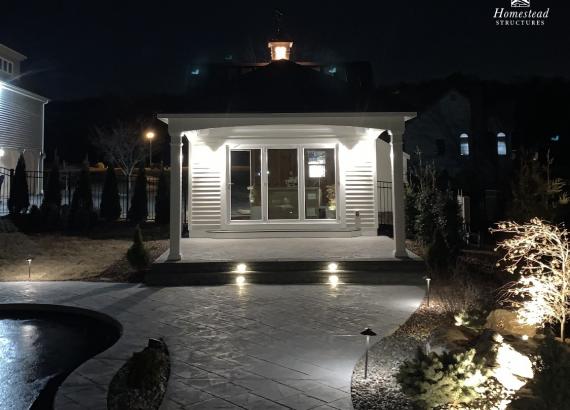 Night shot of lit up custom Liberty Pool House with attached Pavilion in Flemington NJ