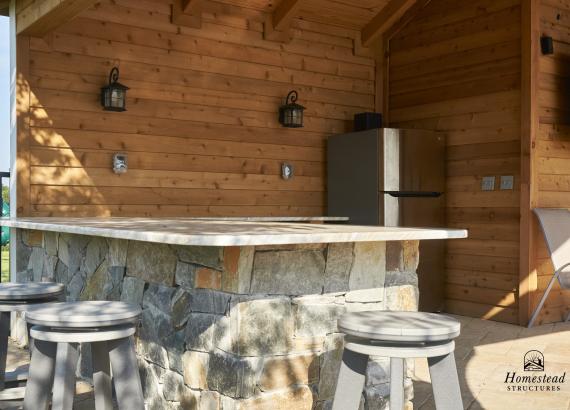 Stone bar with granite countertops in 18' x 22' Timberframe Avalon Pool House