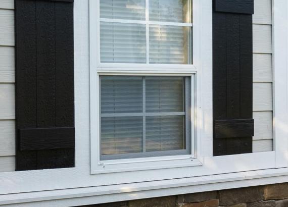 Close-up of vinyl window with black shutters on 18' x 24' Hip Roof Avalon Pool House in Harleysville PA