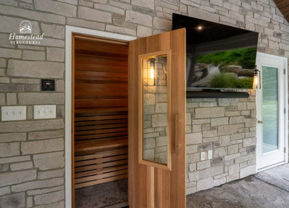 Entrance to a luxurious, cedar-lined sauna integrated within a stone-walled outdoor pool house, complemented by modern amenities.