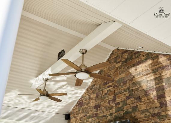 Ceiling fans mounted on cross bean of a-frame ceiling on Avalon Pool House