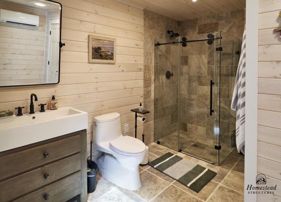 Full bathroom with sink, toilet and shower in custom pool house