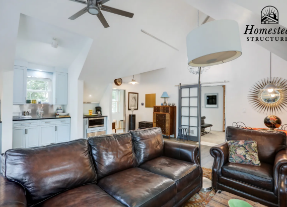Spacious second-level living area with a fully equipped kitchen and entertainment space, designed for comfort and style in a custom garage.