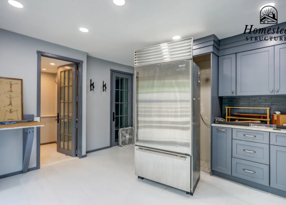Custom-designed kitchen area inside a high-end garage, featuring functional and stylish cabinetry, countertops, and appliances