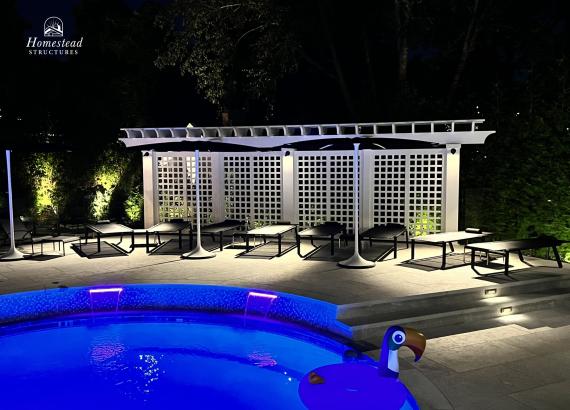 Nighttime shot of 3' x 26' Somerset PVC Pergola with Lattice Privacy Wall