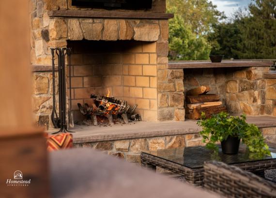 Stone fireplace and wood storage in Timber Frame Pavilion