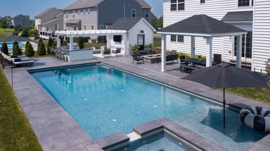 A modern backyard with a home and a pool house